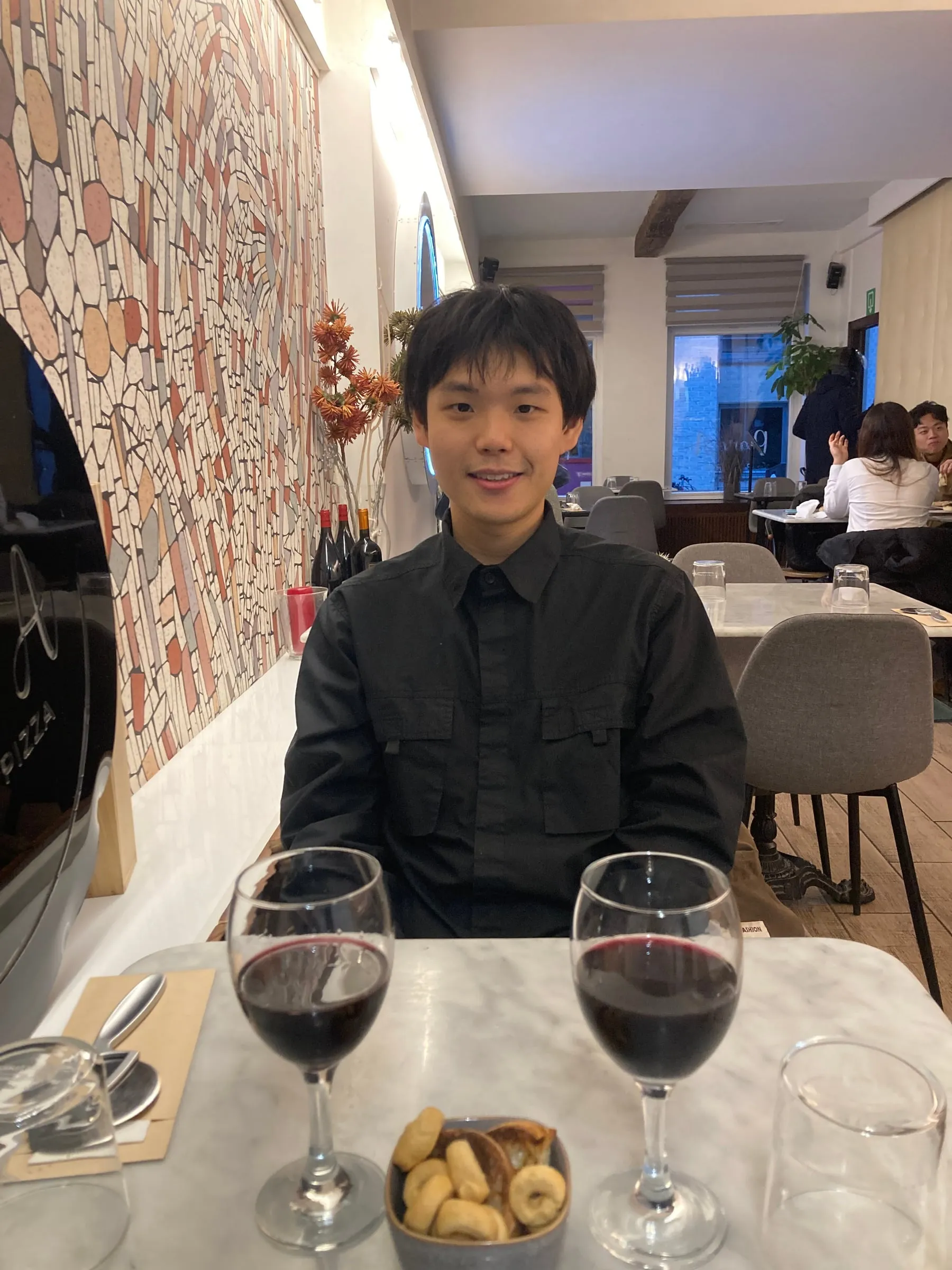 Alan at a restaurant table with two glasses of red wine